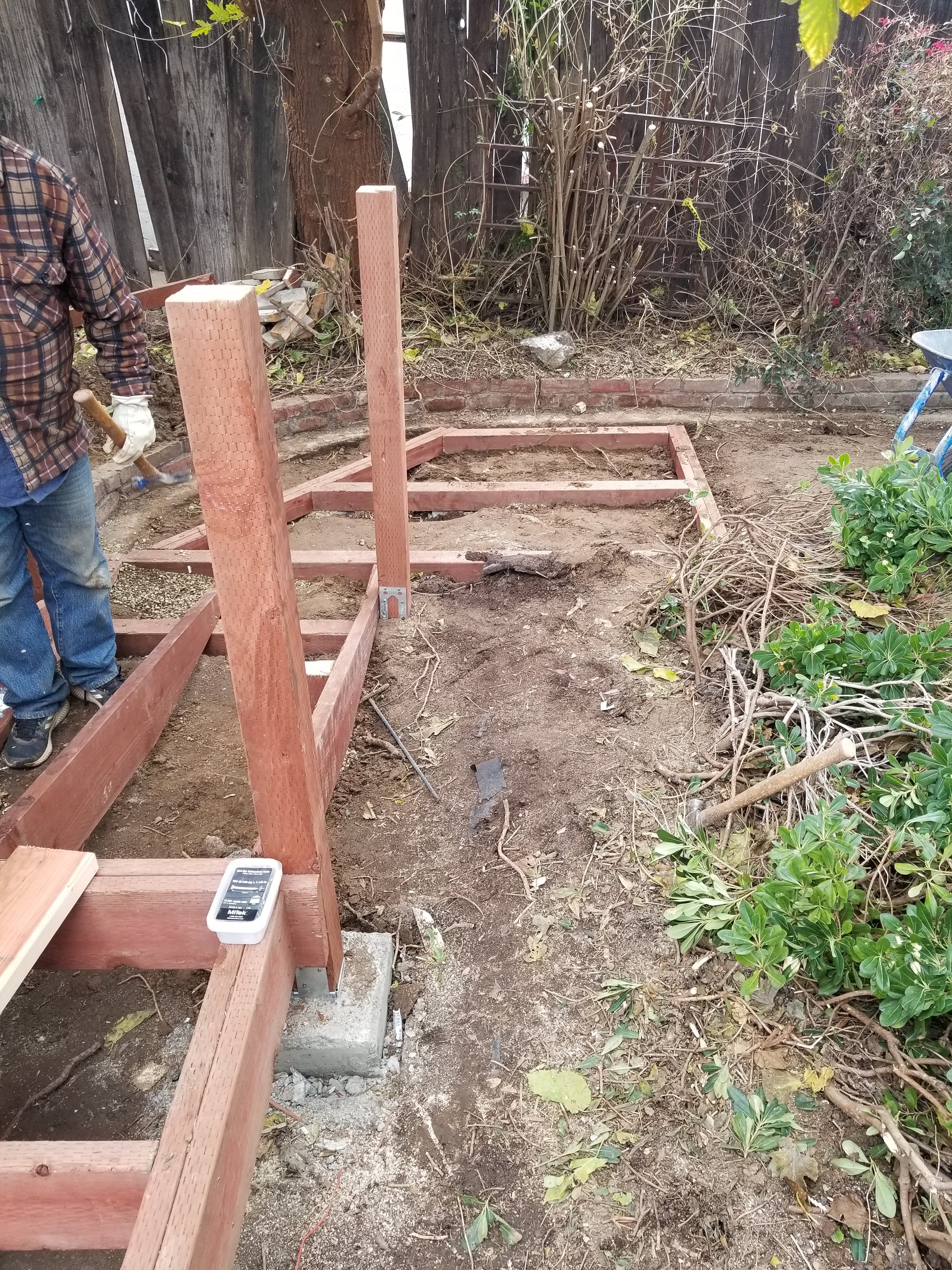 Deck framing with posts on concrete footings and metal connectors