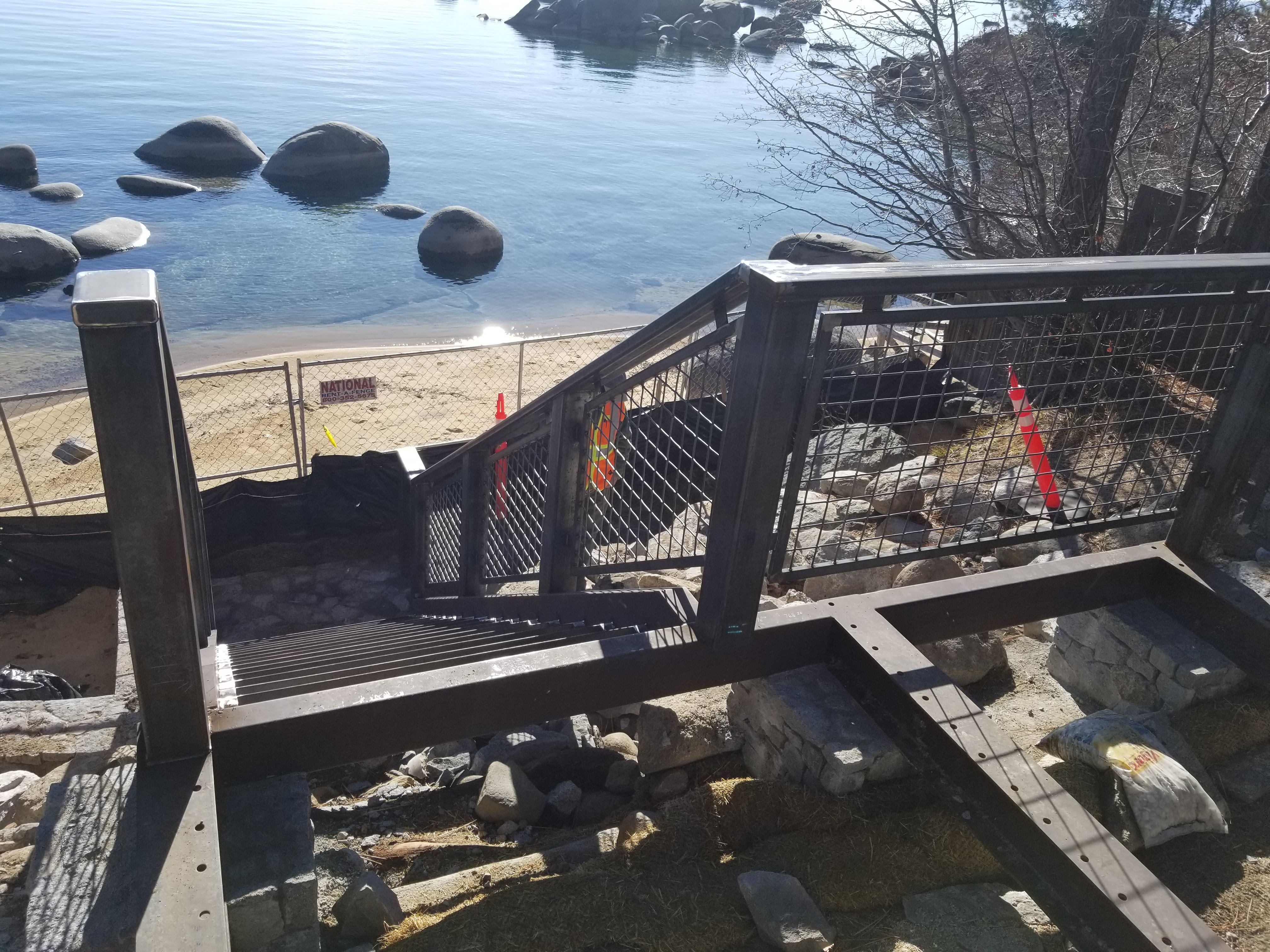 Steel stair and mesh guardrail above a lake shore