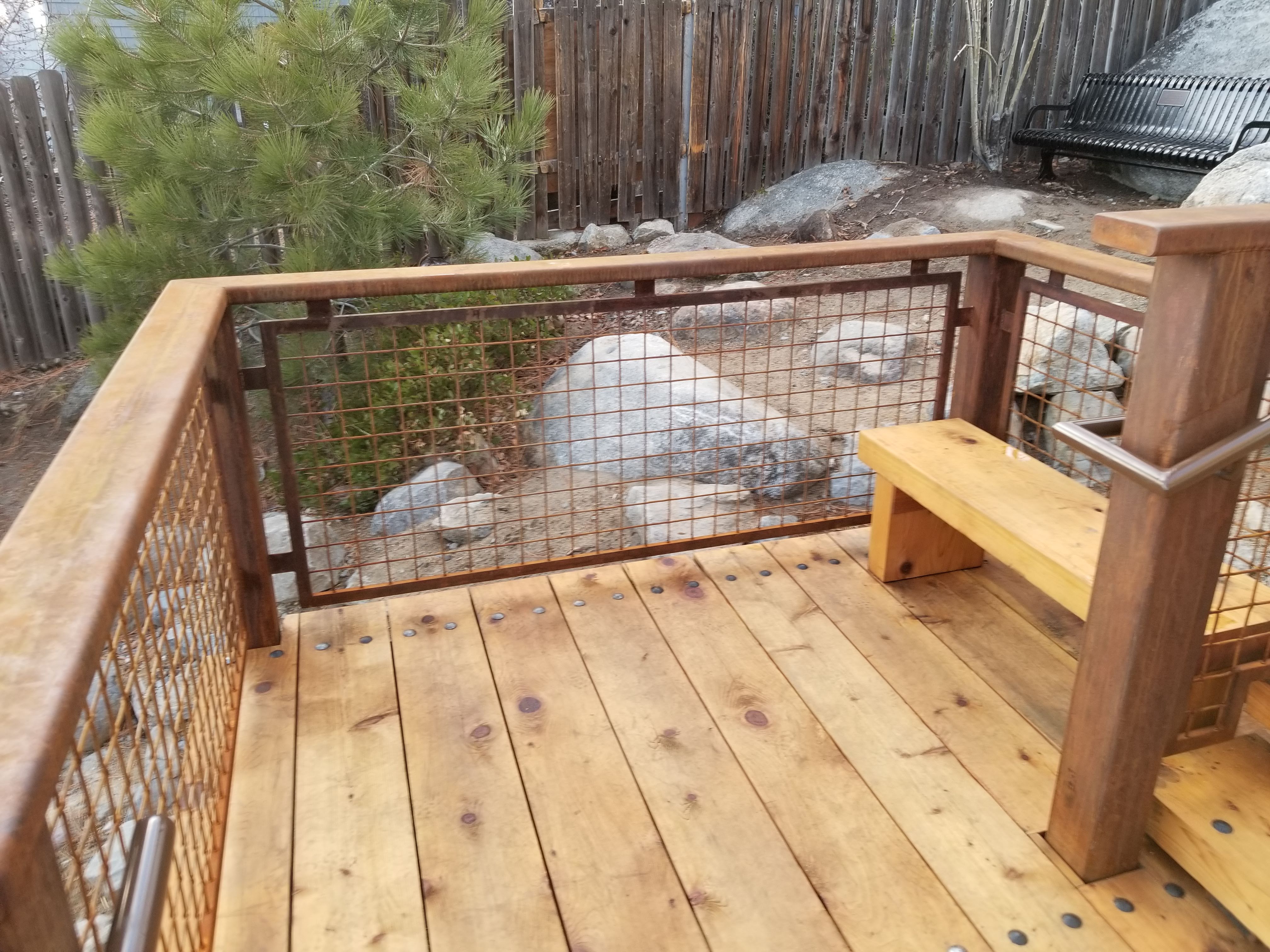 Timber deck landing with mesh guardrail and bench