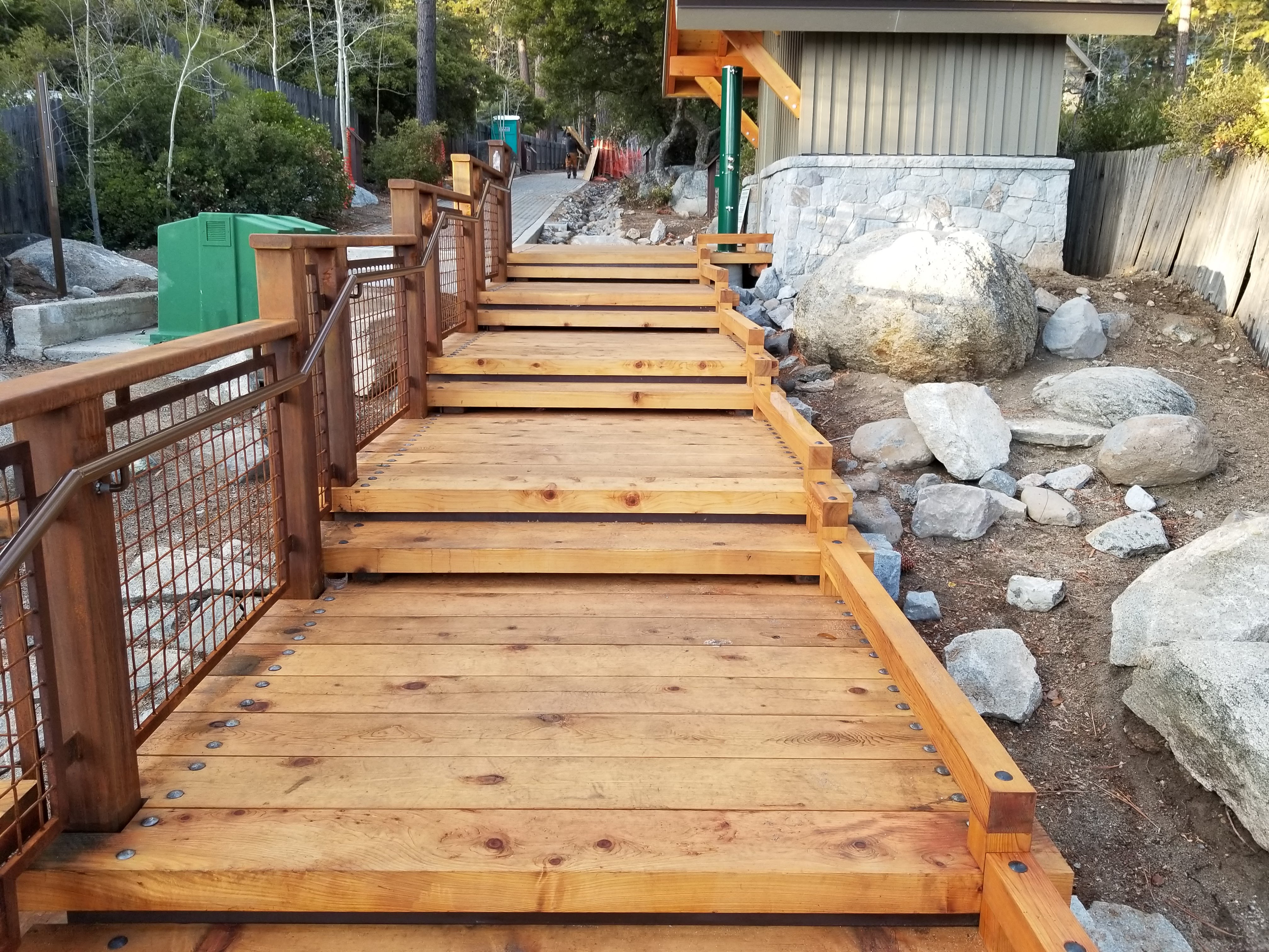 Long timber walkway with steps between landscaped boulders
